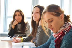 three adults at a table - become an intern