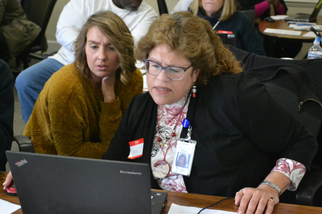 two people around laptop filling out medicaid form at caritas